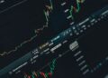 Pantalla de portátil con gráficos de bolsa para elegir un broker e invertir en España