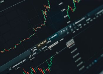Pantalla de portátil con gráficos de bolsa para elegir un broker e invertir en España
