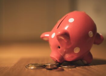 Hucha y monedas que ilustran las comisiones bancarias y el ahorro en España