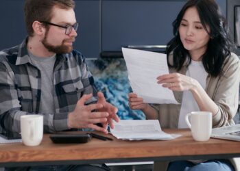 Pareja preocupada revisando facturas y calculando la deuda de minicréditos y préstamos rápidos