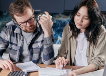 Pareja organizando juntos sus finanzas en pareja y el presupuesto del hogar sobre la mesa