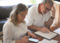 Pareja revisando un PIAS y documentos de ahorro para la jubilación