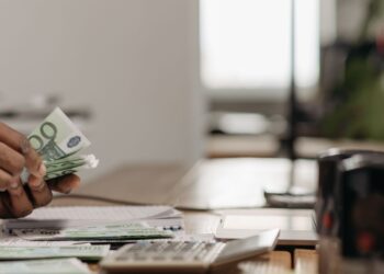 Manos contando billetes de euro junto a una calculadora, ilustrando el salario mínimo 2026 en España