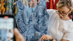 Persona preparando ropa de segunda mano para vender en Vinted y Wallapop desde el móvil