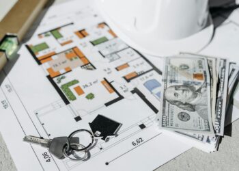 Llaves y dinero sobre un plano: comprar vivienda para alquilar y calcular su rentabilidad
