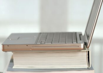 Portátil sobre una pila de libros, imagen para los mejores libros de criptomonedas