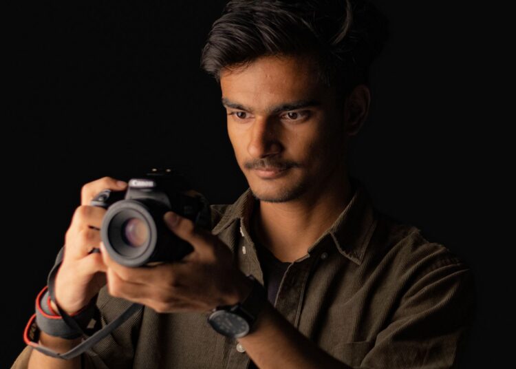 Fotógrafo con su cámara preparando imágenes para vender fotos online
