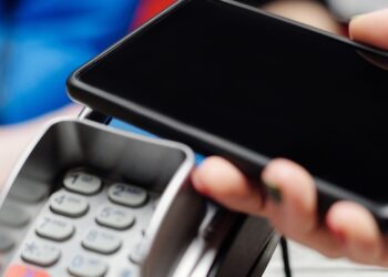 Persona pagando con el móvil mediante Bizum en un comercio