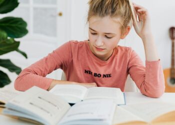 Persona leyendo los mejores libros para invertir en bolsa en un escritorio