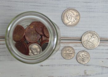 Tarro lleno de monedas que simboliza los gastos hormiga acumulados día a día
