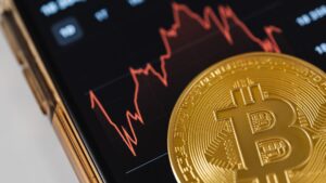 Moneda de bitcoin sobre un gráfico bursátil, símbolo de invertir en un ETF de Bitcoin desde España