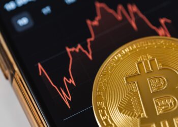 Moneda de bitcoin sobre un gráfico bursátil, símbolo de invertir en un ETF de Bitcoin desde España