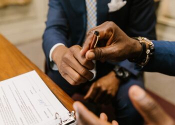 Persona a punto de avalar un préstamo firmando el contrato de aval ante el banco