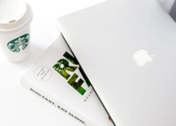 Escritorio con portátil y café para escribir una newsletter de pago
