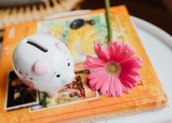 Hucha sobre libros de colores que ilustran los libros de finanzas para niños