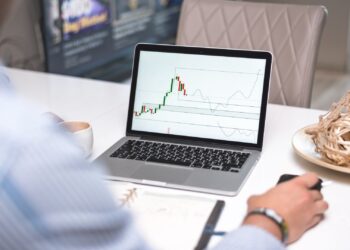 Inversor usando un screener de acciones para filtrar valores en la pantalla de un ordenador