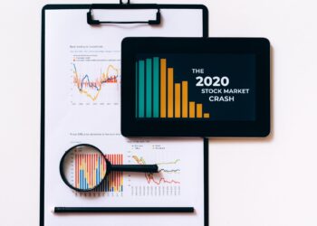 Gráficos económicos a la baja sobre una mesa que ilustran qué es la deflación