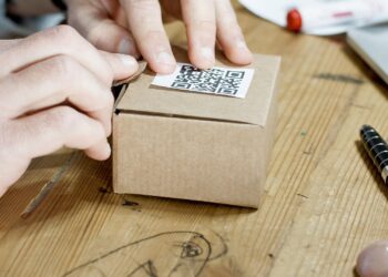 Persona preparando una caja de cartón para vender en Amazon desde España con logística FBA