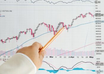 Documentos y gráficos financieros sobre una mesa para planificar un traspaso de fondos de inversión