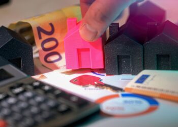 Maquetas de casas, billetes de euro y calculadora sobre una mesa, imagen de apoyo para los mejores libros de inversión inmobiliaria