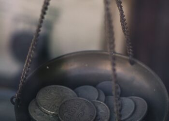 Balanza con monedas que ilustra el apalancamiento financiero y el equilibrio entre deuda y capital