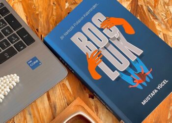 Escritorio con libro, café y portátil para elegir los mejores libros para autónomos